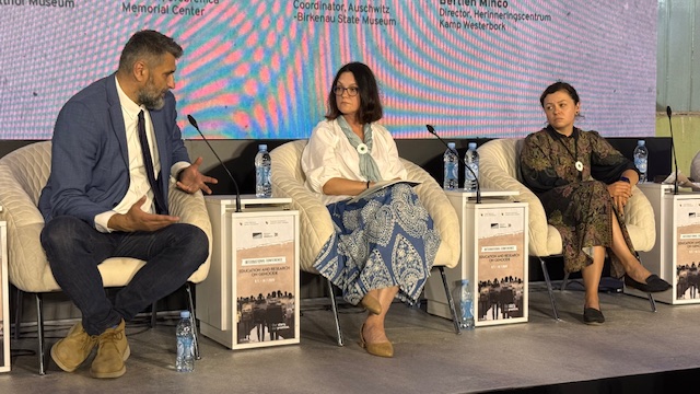 Panel dyskusyjny z udziałem trzech osób – mężczyzny i dwóch kobiet – siedzących na scenie. Mężczyzna po lewej przemawia, kobieta w środku (Ewa Malinowska) uważnie słucha, trzecia panelistka w stroju moro siedzi z rękami skrzyżowanymi. W tle ekran z tytułem wydarzenia i nazwiskami uczestników.